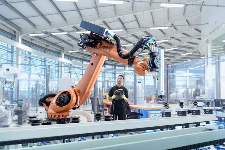 Engineer next to robotic arm on a production line